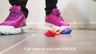 Girl crushing balloons with Fila Disruptor sneakers