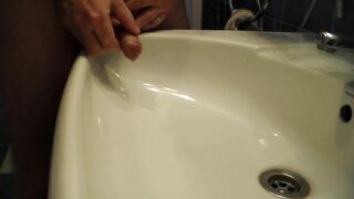 John is Peeing into the Bathroom Sink