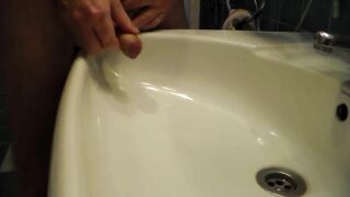 John is Peeing into the Bathroom Sink