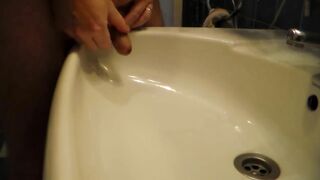 John is Peeing into the Bathroom Sink