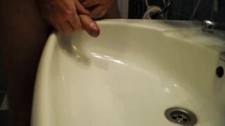 John is Peeing into the Bathroom Sink