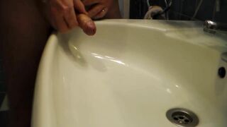 John is Peeing into the Bathroom Sink