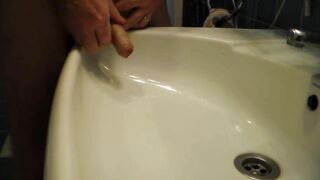 John is Peeing into the Bathroom Sink