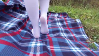 Schoolgirl in uniform shows legs feet foot in white knee socks and pantyhose under skirt