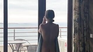 Sexy slender girl flashes her natural bare breasts on her balcony.